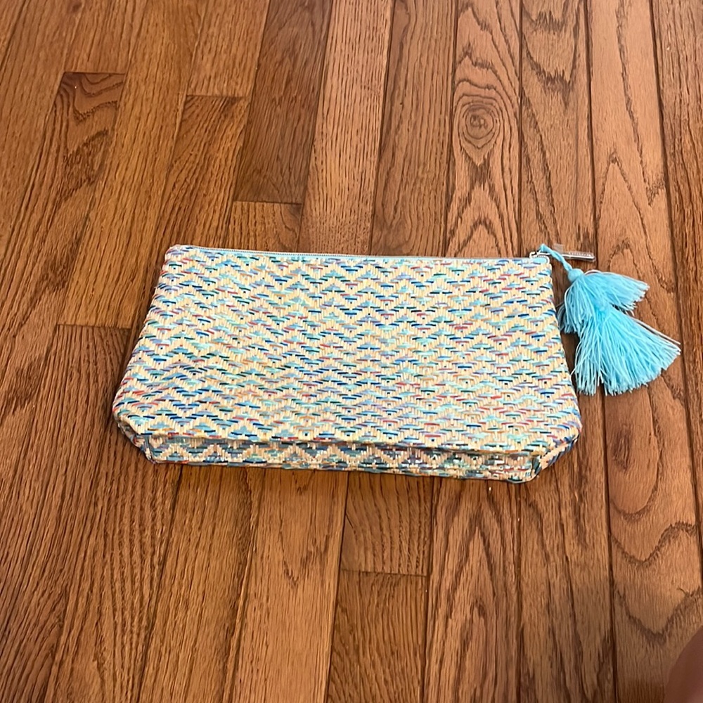 striped design, with a blue pom pom on the zipper